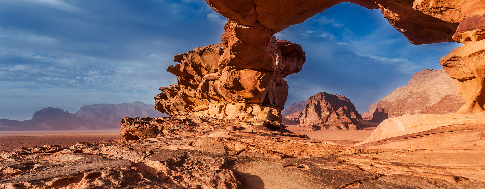 Panoramic view of natural rock bridge and Wadi Rum desert, Jordan