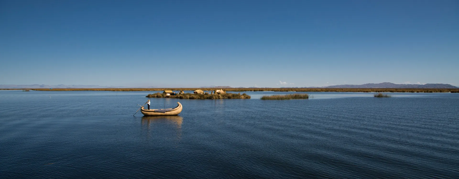Local man on traditional boat on peaceful Lake Titicaca