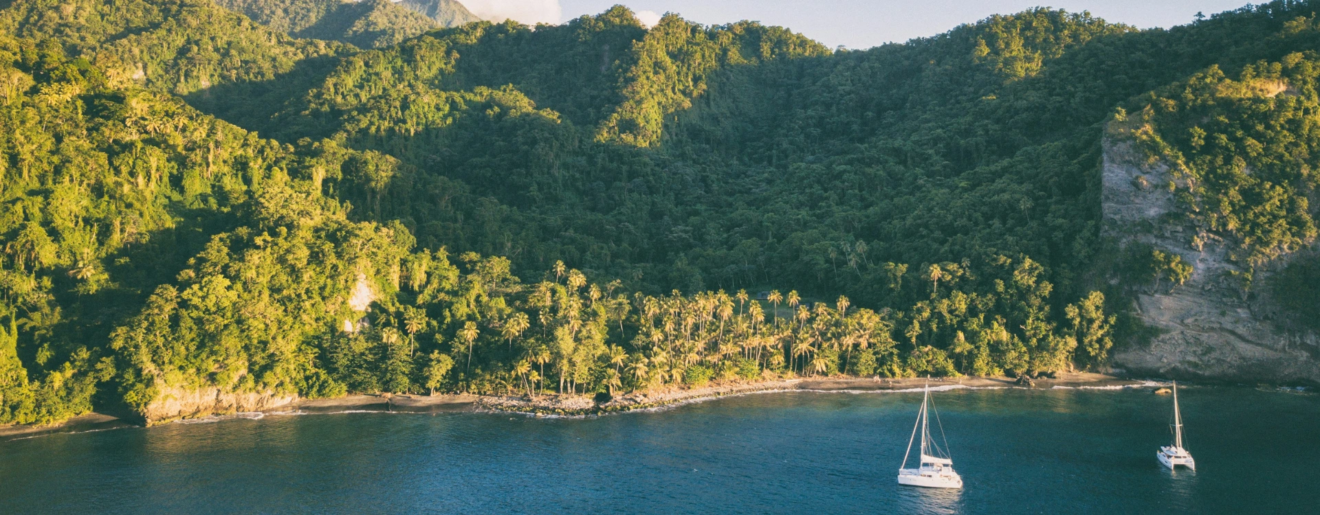 View of yachts with mountains by the Caribbean coastline