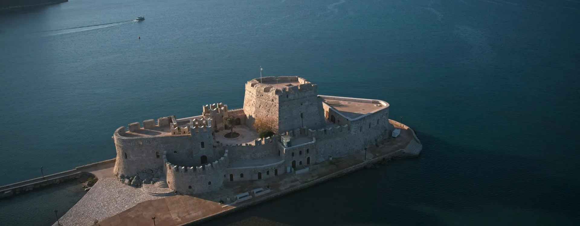Old Grecian building surrounded by the ocean